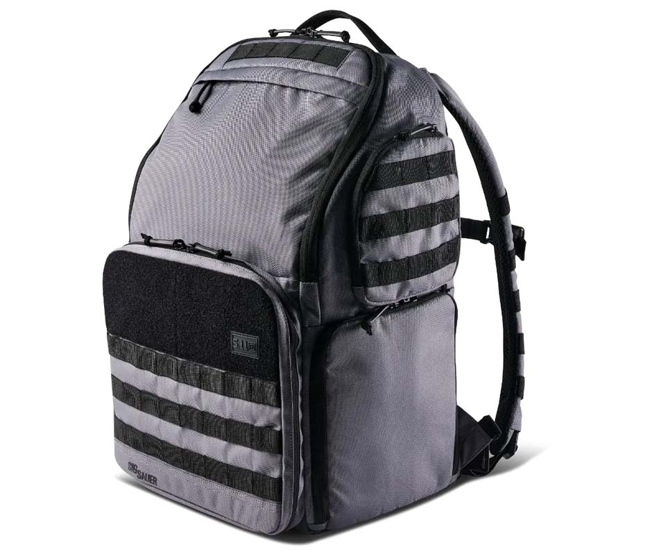 A close-up view of the new 5.11 Tactical SIG Sauer Range Ready Backpack introduced at the 2025 SHOT Show. Crafted with rugged materials, this backpack provides durability and ample storage space for range essentials. It features a dedicated handgun compartment, generous room for ammunition, and multiple pockets to keep shooting gear organized and secure. The padded shoulder straps and adjustable design ensure comfortable carry, even when the bag is fully loaded. Created through a collaboration between 5.11 Tactical and SIG Sauer, it delivers both functionality and a sleek, professional appearance. Ideal for trips to the range or outdoor shooting sessions, this backpack helps shooters stay focused on performance rather than worrying about disorganized gear. The attention to detail and quality construction make it a reliable choice for anyone seeking a dependable range companion.